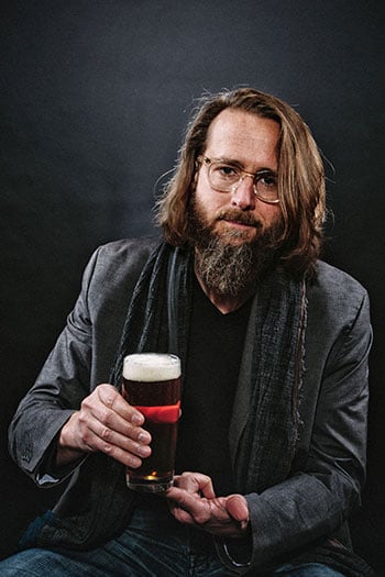 Koch poses, Stone in hand. Stone CEO Founder Greg Koch Beer Connoisseur