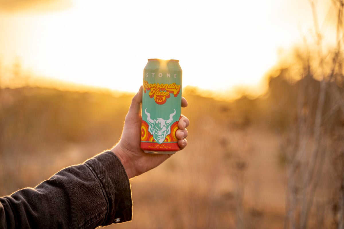 stone brewing co. neverending haze ipa in front of sunset