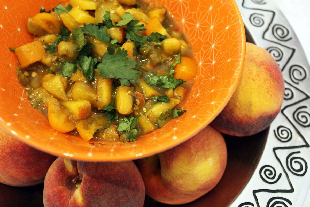 Chili Beer Peach Pico De Gallo in a bowl with peaches beneath