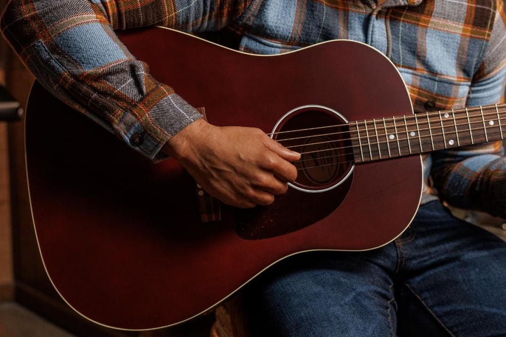 close-up of gibson acoustic guitar being strummed
