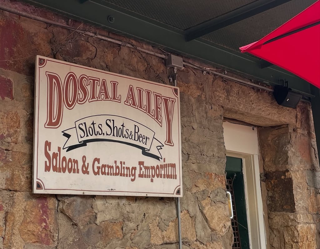 Sign for dostal alley advertising "shots, slots, and beer"