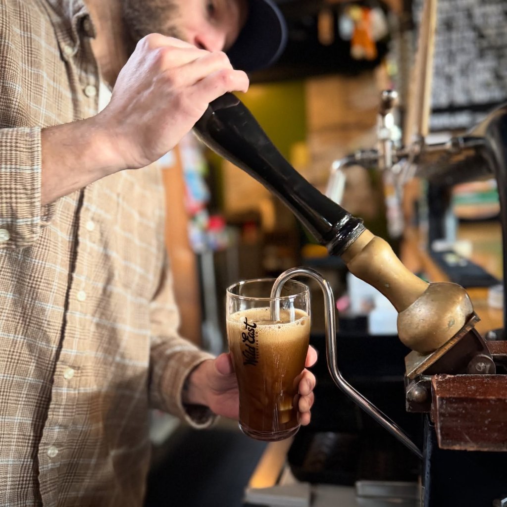 Dark beer being poured from an hand pump
