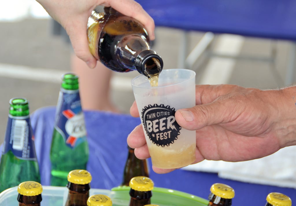 Beer being poured from a bottle into a plastic festival cup